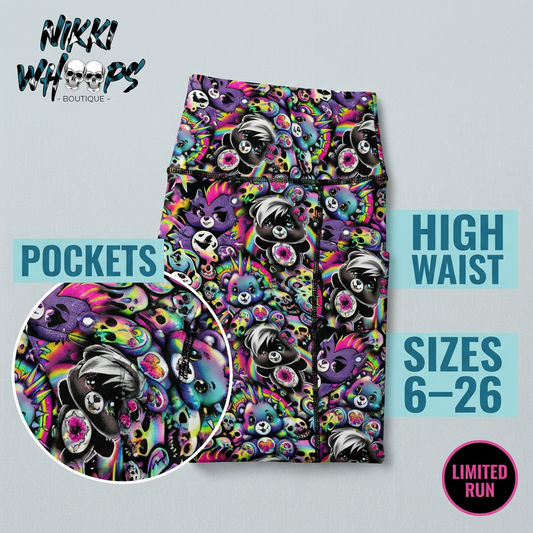 Colourful Don’t Care Bears sport shorts featuring pastel bears, rainbow skulls, spikes, hearts, and punk-inspired graphics on a black background