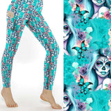mock up of Ethereal Elegance Day of the Dead Full-Length Leggings featuring sugar skull women with flowing blue hair, surrounded by butterflies and roses on an aqua background.