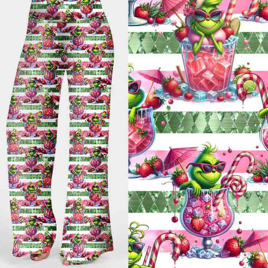 Wide leg lounge pants featuring playful green Grinch-inspired characters lounging in pink cocktails with candy canes, fruit, and festive details by Nikki Whoops Boutique.