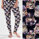 A pair of women's full-length joggers featuring a colorful print of cats wearing Victorian-style clothing against a dark background. The joggers are displayed from two angles, one showcasing the front view and the other highlighting the back.