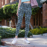mockup of lady wearing Blue gothic leggings with skeleton brides, crows, potion bottles, bats and ornate Victorian elements on a patterned background.