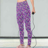 Mockup of lady wearing of Violet Femmes leggings. La Catrina images with flowing hair with tints of pink, mauve and blue. vibrant pink and purple flowers in their hair on a rich purple background by Nikki Whoops Boutique.