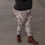 Gray leggings with skull and red splatter design, paired with burgundy combat boots on gray pavement.