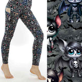 A pair of women's leggings featuring a pattern with cartoon emo bats in various poses and expressions, predominantly in shades of gray, with side pockets.