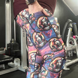 lady wearing leggings featuring vampire-inspired female portraits framed in gothic cameos with roses, set against a purple and fiery sunset background.