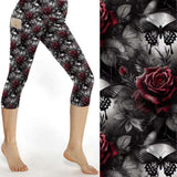 Capri leggings featuring glowing blue butterflies, skulls, and dark florals under a moody purple and black backdrop
