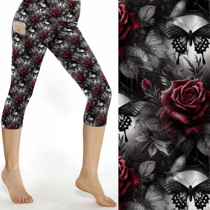 Capri leggings featuring glowing blue butterflies, skulls, and dark florals under a moody purple and black backdrop