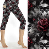 Capri leggings featuring glowing blue butterflies, skulls, and dark florals under a moody purple and black backdrop