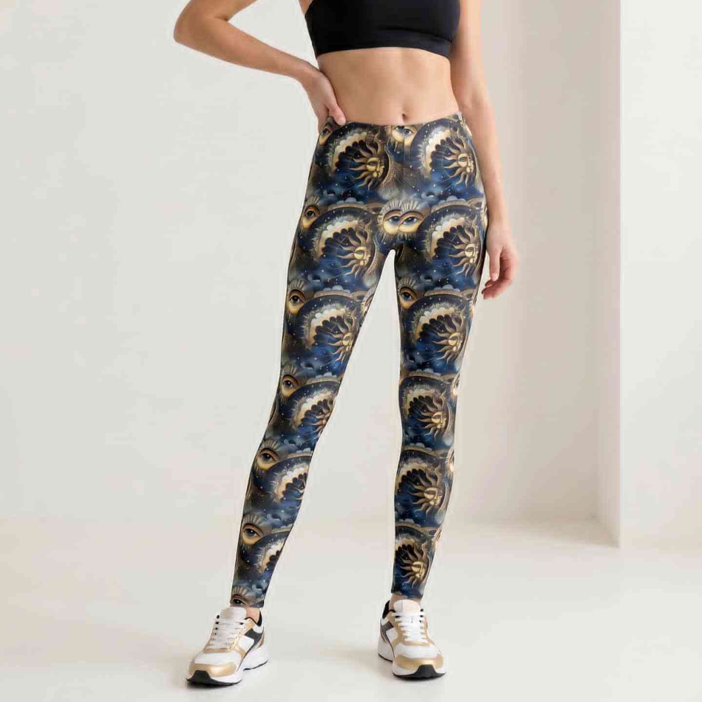 Person wearing leggings featuring celestial sun and moon faces, all-seeing eyes, stars and mystical astrology-inspired artwork in navy and gold tones