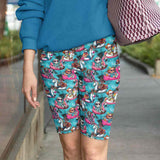 girl wearing shorts featuring cartoon horror movie villains on unicorn and flamingo blow up toys