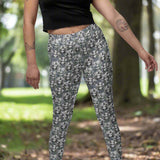 lady wearing monochrome leggings of La Catrina, with floral patterns and a Day of the Dead theme.