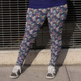 girl wearing leggings featuring a floral and skull pattern, with an assortment of hats and vibrant rainbow roses on the brims of the skulls.