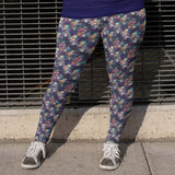 girl wearing leggings featuring a floral and skull pattern, with an assortment of hats and vibrant rainbow roses on the brims of the skulls.
