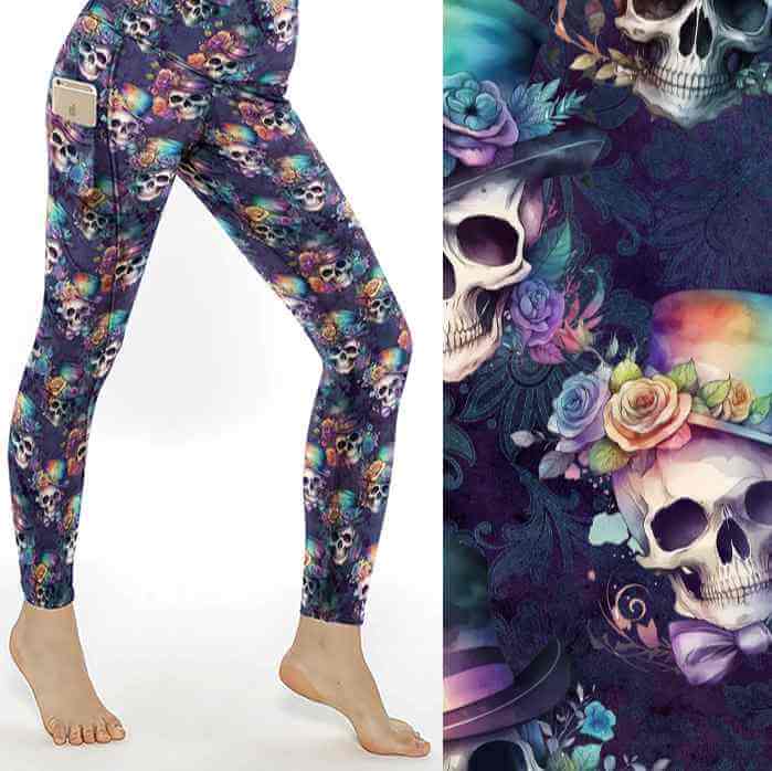 A pair of leggings featuring a floral and skull pattern, with an assortment of hats and vibrant rainbow roses on the brims of the skulls.
