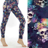 A pair of leggings featuring a floral and skull pattern, with an assortment of hats and vibrant rainbow roses on the brims of the skulls.
