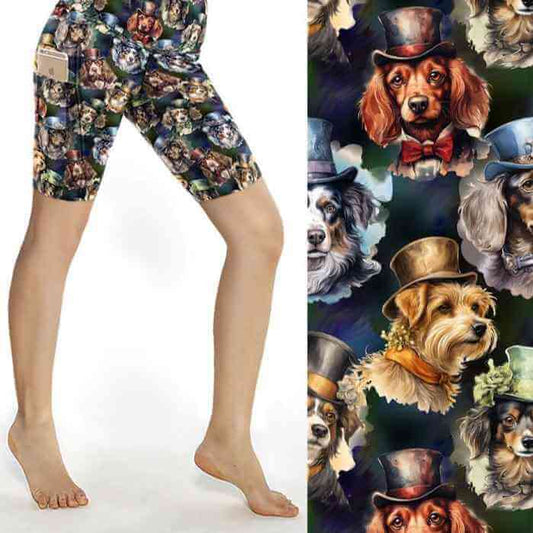 A pair of knee-length shorts featuring a whimsical print of various dogs wearing top hats and bow ties on a dark green background. The shorts are designed with a wide 12cm waistband and side pockets.
