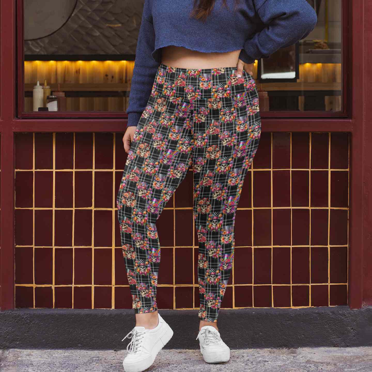 mockup of lady outside a building wearing Dead Fancy Like Vintage-style skull leggings featuring fancy skeletons and brocade floral elements on a black and white plaid background by Nikki Whoops Boutique.