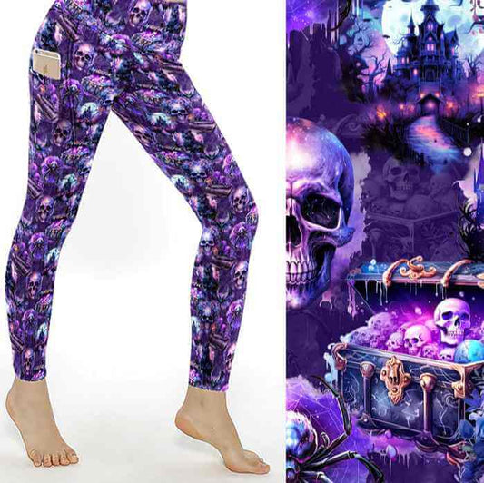 A pair of leggings featuring a Halloween-themed pattern with skulls, bats, and a haunted house against a purple background.