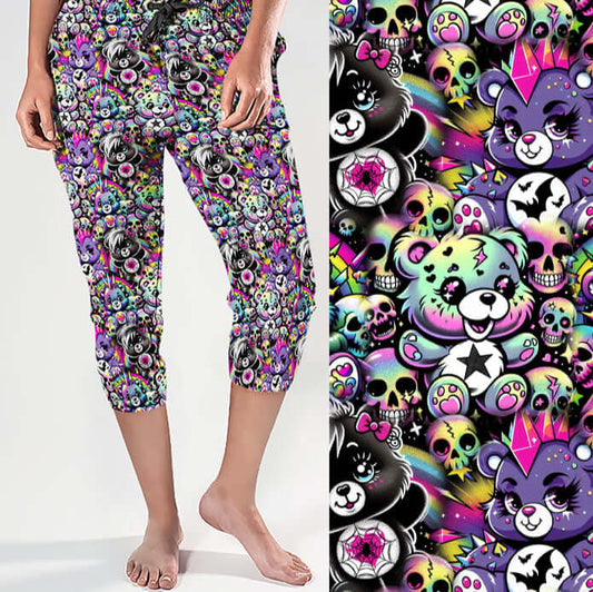 Capri jogger pants featuring punk pastel cartoon bears, rainbow skulls, stars, bats and spider webs on a bright purple background. Colourful, edgy and cute with attitude.