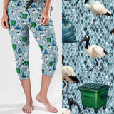 Capri jogger pants featuring Australian ibis birds known as bin chickens, along with green wheelie bins and rubbish bags on a textured blue background. Playful and humorous design.