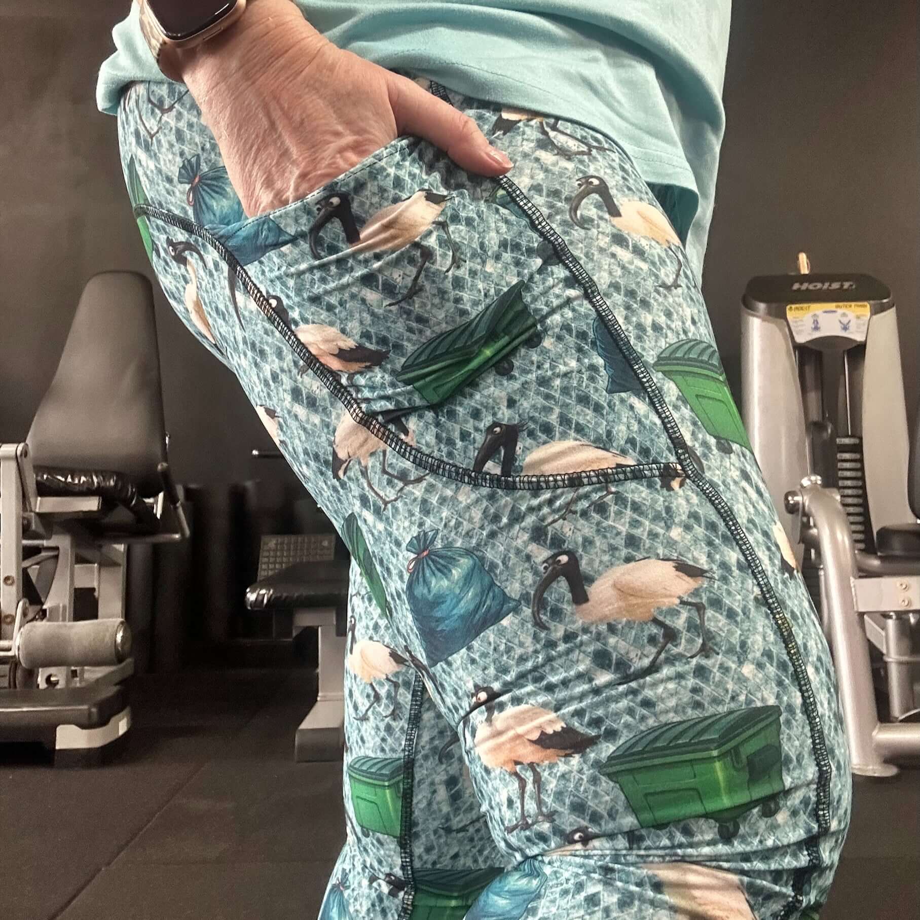 Person wearing patterned pants with nature-themed design in a gym setting