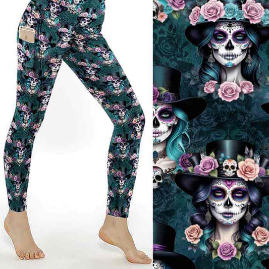 Leggings with Day of the Dead skull design, featuring roses and top hats on a dark green background; close-up shown.
