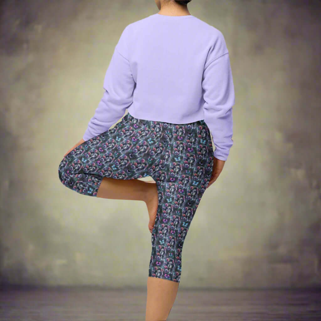 Gothic Glamour capri leggings on girl in tree pose. Elegant La Catrina images in grey blue tones. Pink and purple roses in her hair, surrounded by flowers and butterflies.