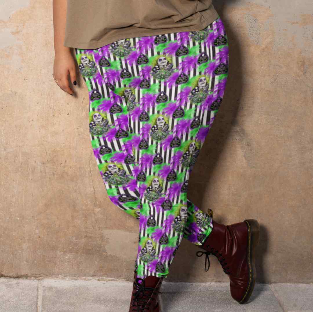Person wearing colorful leggings with spooky faces, stripes, and text pattern, paired with brown boots