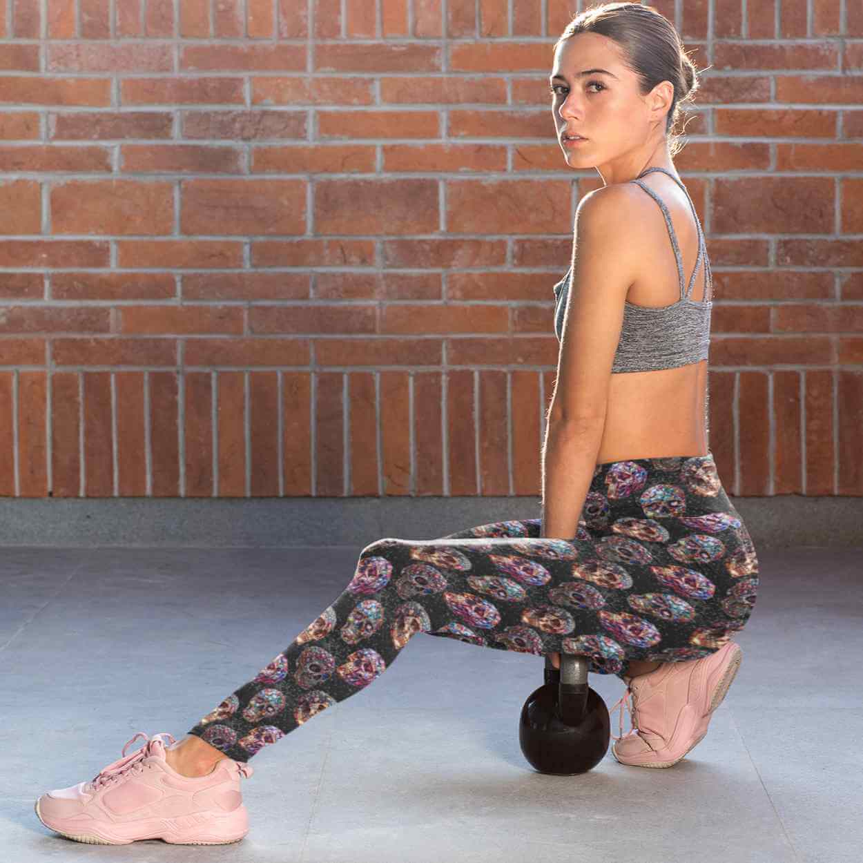 Ladt wearing Leggings featuring vibrant gemstone skulls in pink, blue, and gold hues against a glittering black background.