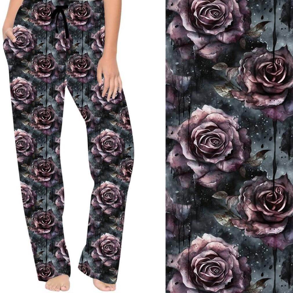 A pair of lounge pants featuring a pattern of dark, aubergine-colored roses on a dark grey/green background with a wide waistband and drawstring.