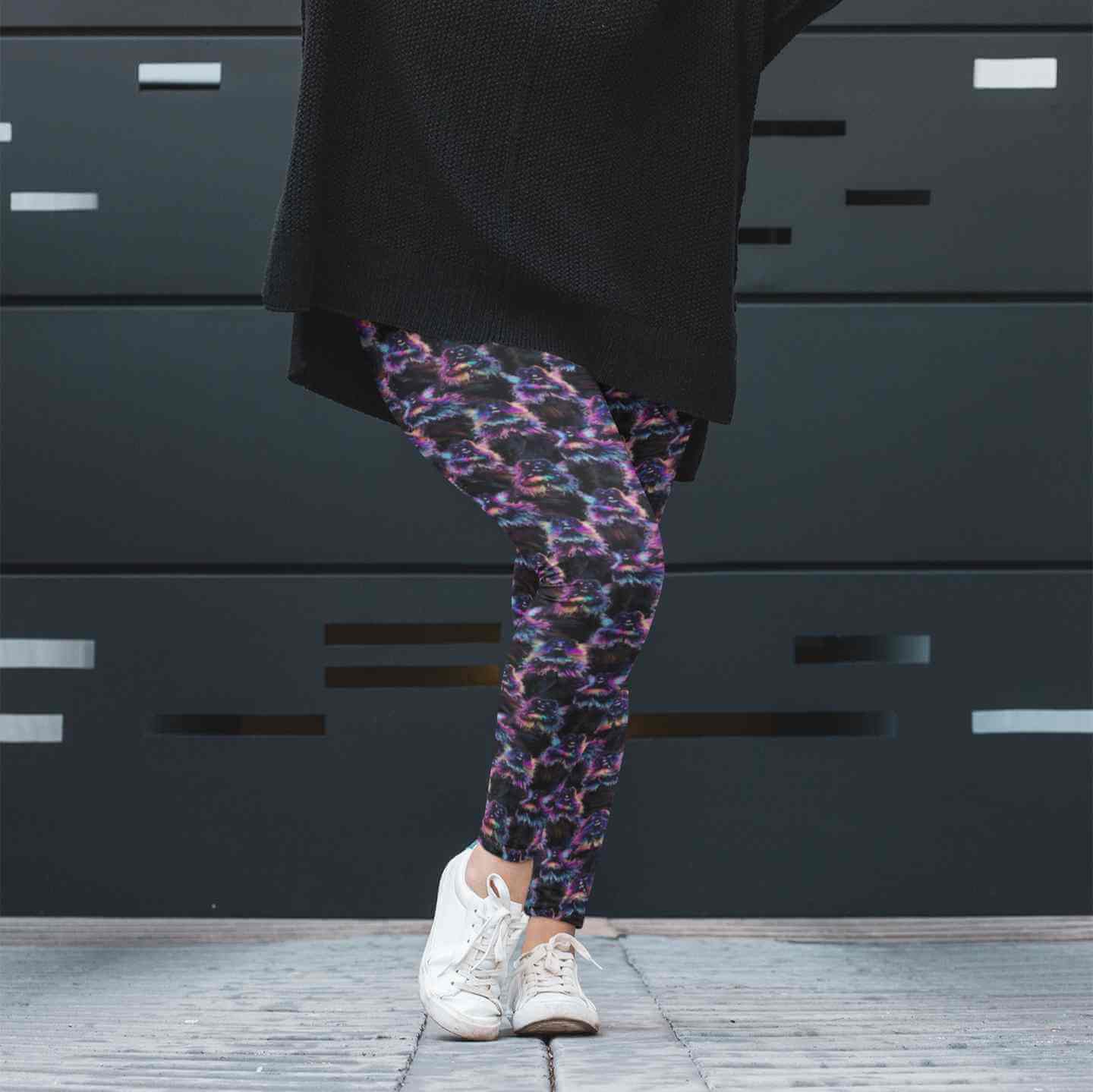 Person wearing colorful patterned leggings and white sneakers in front of a dark background