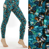 A pair of leggings featuring a whimsical pattern with fairies and bats against a starry night background, adorned with a floral pattern on the pockets.