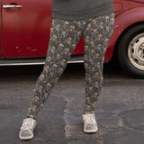 girl standing in front of a red car wearing leggings featuring a pattern with cartoon-style meerkats in punk fashion, including skulls and mohawks, displayed alongside a side pocket with a phone.