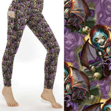 A pair of leggings featuring a detailed, whimsical dark fantasy design with a creature resembling a dragonling, in a pattern of deep shades of blue, purple, and black against a shadowy background.