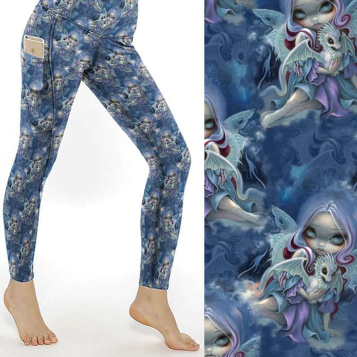 Wintry Dragonling Strangelings Leggings featuring an ethereal gothic-eyed fairy holding a baby dragon, set against a magical winter night sky in deep blues and lilac by Nikki Whoops Boutique.