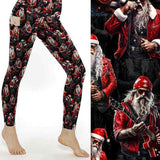 Black leggings featuring tattooed rock-star Santa in red leather jacket with guitars and microphones under moody stage lights by Nikki Whoops Boutique.