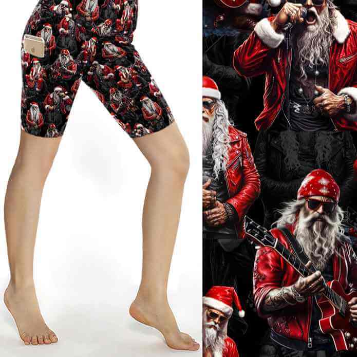 Black Christmas sports shorts with tattooed rock-star Santa in red leather jacket surrounded by guitars and microphones under stage lights by Nikki Whoops Boutique.