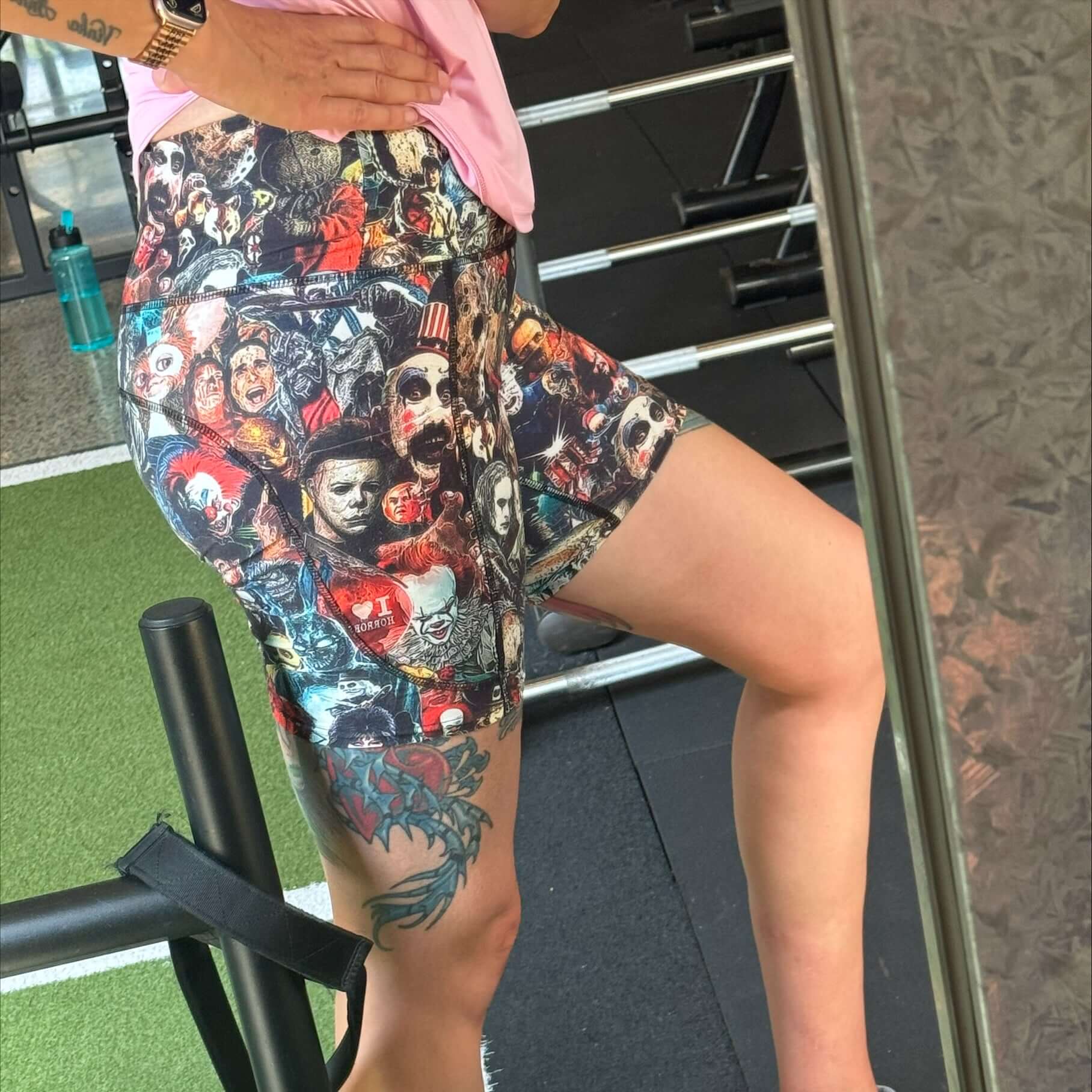 Person wearing colorful movie monster graphic shorts in a gym setting