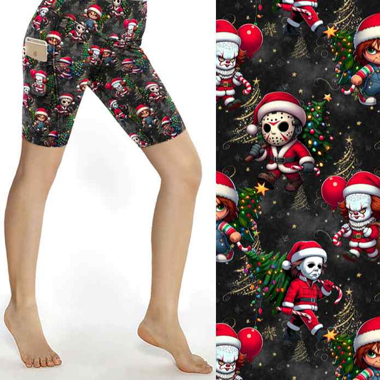 Black Christmas sports shorts with chibi horror icons Freddy, Jason, Michael, Pennywise and Chucky in Santa outfits surrounded by gold stars and lights by Nikki Whoops Boutique, next to a close-up of the pattern.