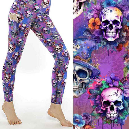 Leggings with colorful skulls, flowers, and wizard hats on a purple background; close-up shows vivid details.