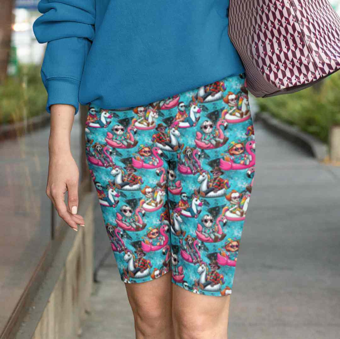 girl wearing shorts featuring cartoon horror movie villains on unicorn and flamingo blow up toys