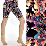 Sport shorts featuring neon Wonderland silhouettes of Alice, Cheshire Cat, and the Mad Hatter on a vibrant rainbow background.