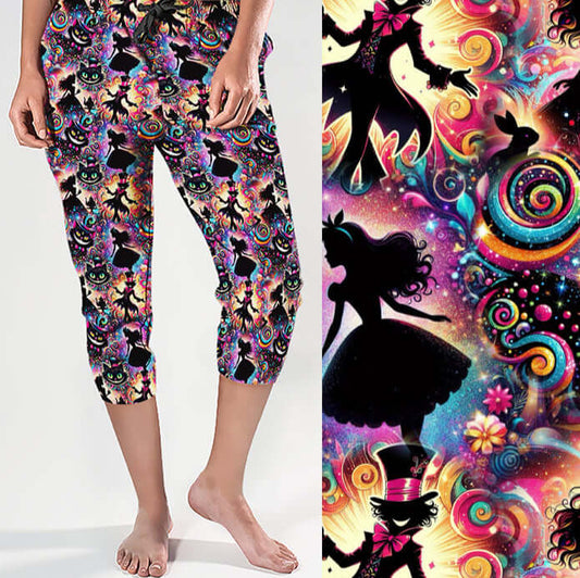 Capri jogger pants with a Wonderland theme featuring black silhouettes of Alice, the Mad Hatter, rabbits and cats. Neon rainbows, spirals, glitter, stars and candy swirls pop against a colourful cosmic background.