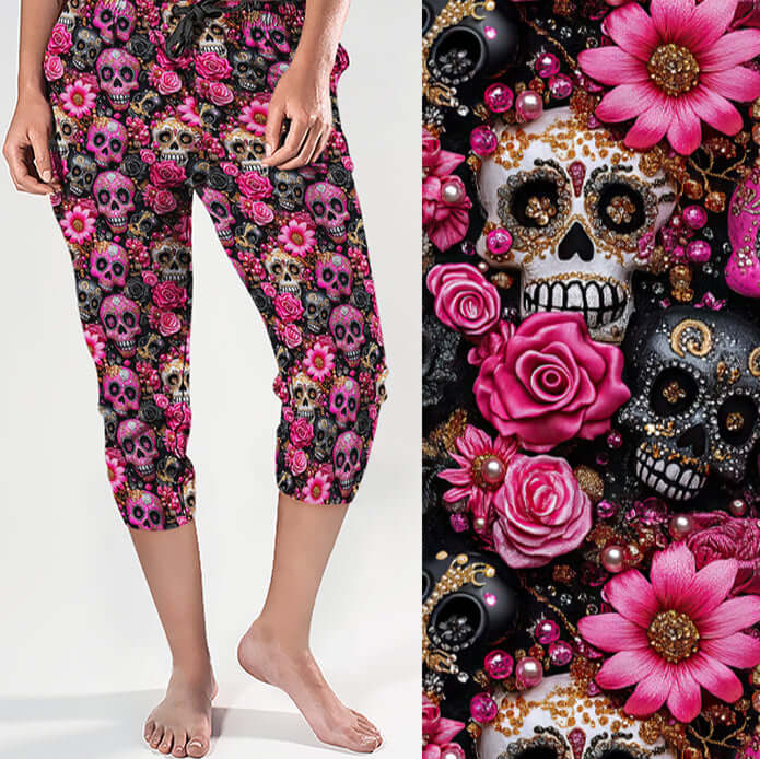 Capri jogger pants featuring a vibrant print of sugar skulls, pink roses, gold details and glittery embellishments on a black background. Feminine and gothic with glam flair.