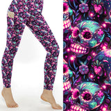 Electric Dreams Skull Print Leggings With Pockets featuring vibrant neon sugar skulls in pink, purple and turquoise on buttery-soft full-length leggings with side pockets.