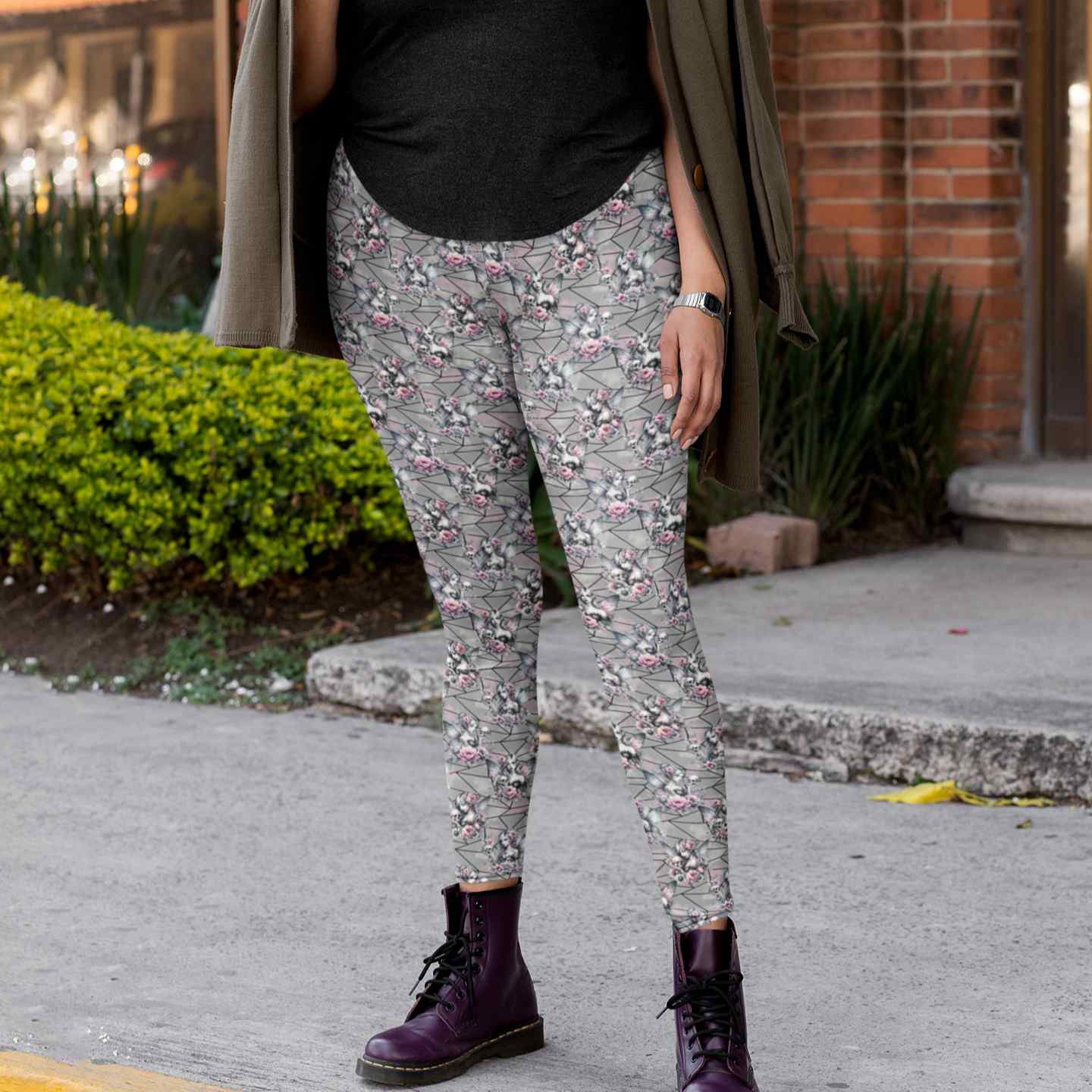 Person wearing floral leggings and purple boots on a sidewalk.
