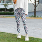 Person wearing Killing Me Softly - Skull full length leggings floral pants and white sneakers standing on grass with a blurred background by Nikki Whoops Boutique.
