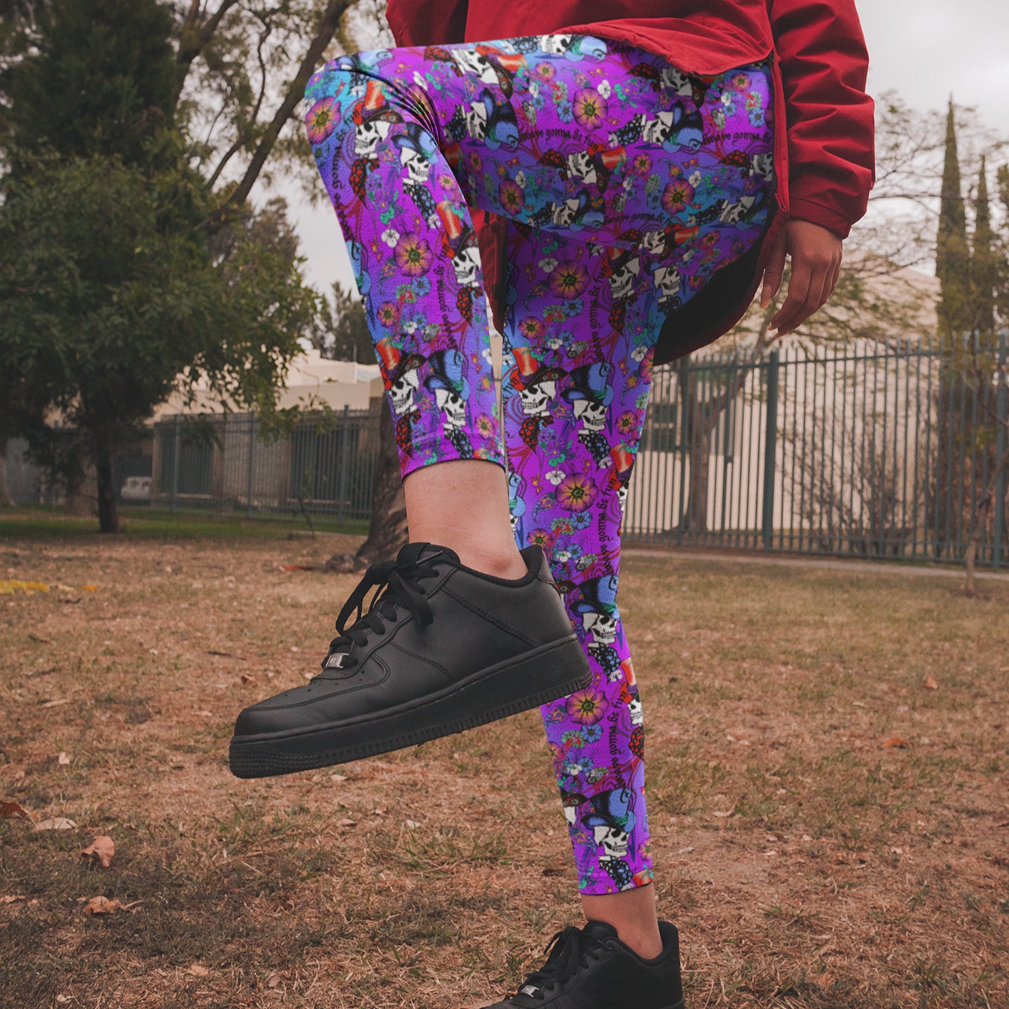 Person wearing colorful floral pants and black sneakers in an outdoor setting