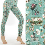 Victorian Voyage Steampunk Leggings With Pockets featuring vintage steampunk suitcases, pocket watches, gramophones, roses and antique accessories on mint green full-length leggings with side pockets.