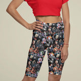 Person wearing black leggings with colorful character pattern on a beige background